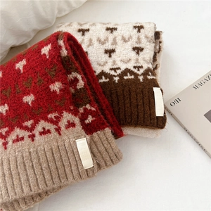 Detail of geometric jacquard knit scarf with ribbed edges and woven brand label