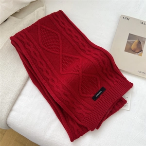 Detailed close-up of red cable knit 100% wool scarf featuring a soft textured rib edge
