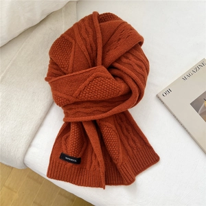 Macro shot of 100% wool scarf showing cable knit texture in retro caramel rust color