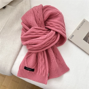 Detail of pink cable knit 100% wool scarf featuring thick soft texture and ribbed edges