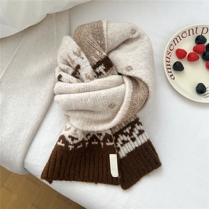 Detailed texture of Fair Isle pattern and ribbed cuffs on the knitted wool blend scarf