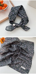 Détail d'un foulard en coton vert foncé à fleurs avec étiquette 100% coton pur