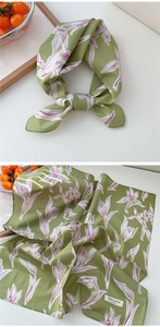 Détail d'un foulard en coton fleuri vert herbe montrant la texture et le motif