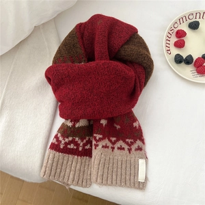 Detailed knit texture and Nordic pattern of a thick red and brown winter scarf