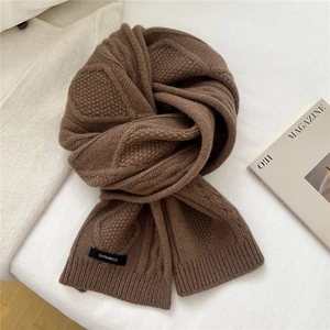 Detail of coffee brown wool scarf showing heavy cable knit texture and 100% wool label