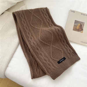 Close-up of thick chunky knit wool scarf with 100% wool label and cable pattern