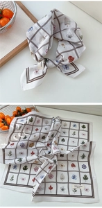 Détail d'un foulard carré en coton imprimé floral avec bordure à carreaux et motifs de feuilles