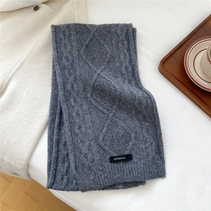 Detail of grey wool scarf featuring thick cable knit texture and 100% wool material