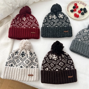 Cozy knit beanie with snowflake patterns and pom-poms in various winter colors