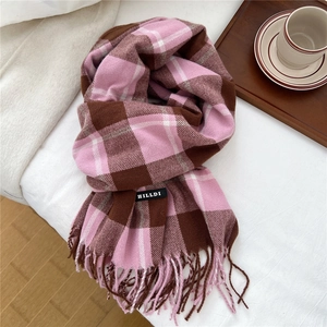 Makro-Detail von Schal mit rosa-kaffeebraunem Karomuster, Fransen und Markenlabel