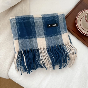 Detail eines blau-weiß karierten Schals mit langen Fransen und einem Leder-Markenlabel