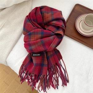 Detail eines rot-blauen Karo-Winterschals mit Fransen und gewebtem Logo-Etikett