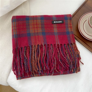 Nahaufnahme des rot-blauen Plaid-Winterstrizals mit Fransen und Markenetikett