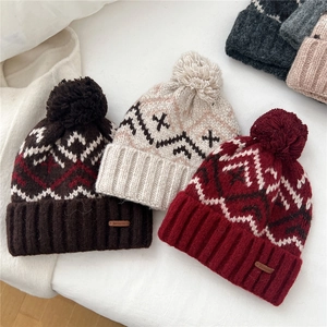 Women's winter knit pom-pom beanie with Nordic pattern and cozy fleece lining