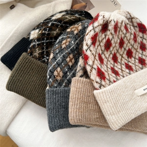 Detail showing various color options of argyle patterned knit beanies for winter