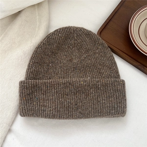 Detail of knit wool beanie featuring speckled yarn texture and ribbed cuff design
