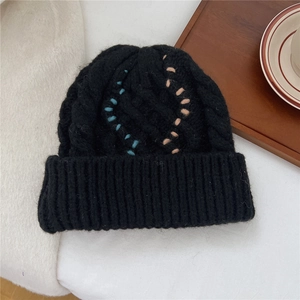 Detailansicht der schwarzen Strickmütze mit blauen und beigen dekorativen Nähten