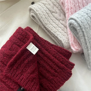 Macro shot of thick wool blend knitted scarves in burgundy, beige, pink and grey colors