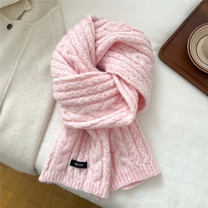 Close-up of thick pink cable-knit wool blend scarf texture and brand woven label