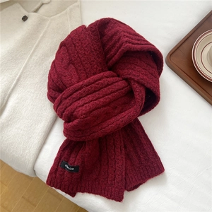 Close-up of chunky knit pattern on wine red wool scarf with BOWLOW brand label detail