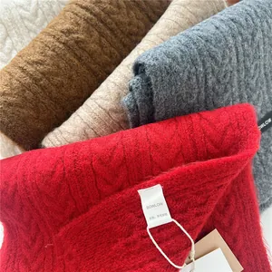 Close-up of wool blend knit scarves showing the soft texture and cable pattern