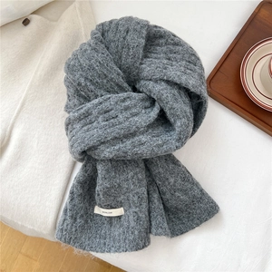 Detailed texture of thick grey wool blend knit scarf with woven BOWLOW brand label