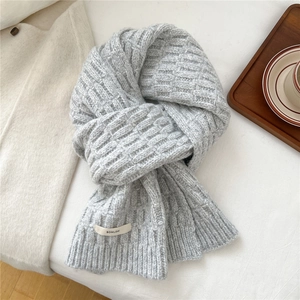 Detail of light grey wool blend scarf showing thick knit texture and brand label
