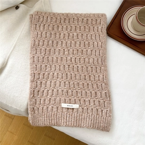 Detail of light coffee wool blend knit scarf with textured checkerboard pattern and logo