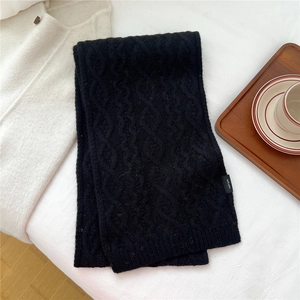 Close-up of black 100% wool knit scarf featuring premium cable knit texture and warmth