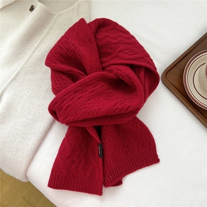 Close-up of deep red 100% wool knit scarf featuring thick chunky cable patterns
