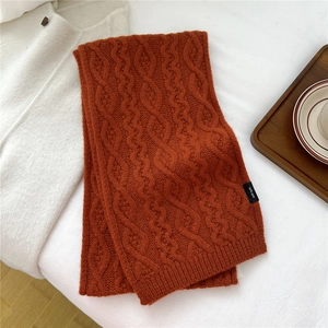 Macro view of orange cable knit 100% wool scarf with soft texture and winter lifestyle items