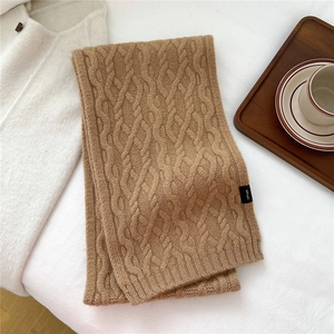 Detailed macro of camel cable-knit pattern and 100% wool label on warm winter scarf