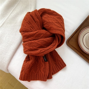 Macro view of caramel twist-knit wool scarf detail with 100% wool product label