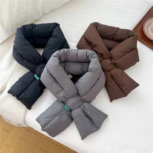 Three solid color padded scarves in black, grey and brown on white bedding