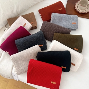 Chunky knit wool scarves in multiple colors with ribbed texture and leather tag