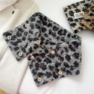 Detail of leopard print plush scarf with golden snap button and soft faux fur texture