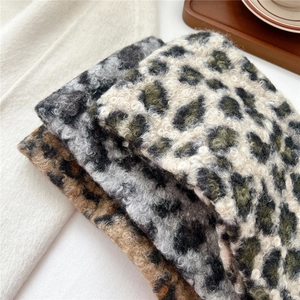 Close-up of soft leopard print plush scarves in brown, gray and green thick fleece texture