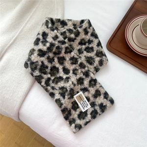 Close-up of leopard print plush scarf with thick faux shearling texture and woven label