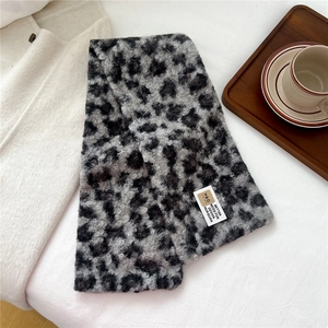 Detail of plush leopard print faux fur scarf with soft texture and brand label