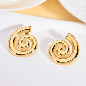 Macro detail of gold spiral stud earrings featuring a polished irregular geometric finish