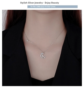 Close-up of a sterling silver butterfly and crescent moon necklace with white zircons