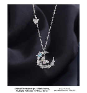 Detailed view of 999 silver crescent moon necklace with enamel butterfly charms and gems