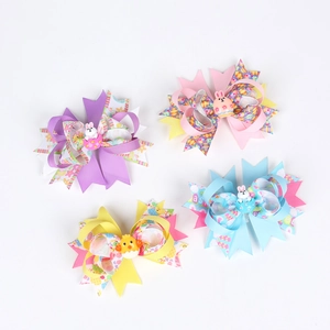 Flat lay set of four Easter themed ribbon hair bows with colorful egg patterns and bunnies