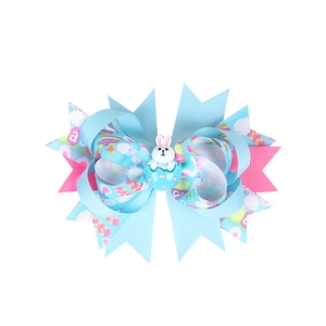 Easter girl hair bow clip featuring blue and pink ribbons with bunny and egg charms