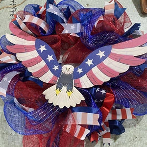 Detail of Fourth of July wreath showing eagle motif and red blue mesh ribbon textures