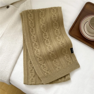 Détail d'une écharpe en tricot 100% laine kaki avec texture torsadée épaisse