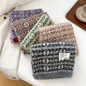 Écharpes classiques en tricot aux motifs géométriques vintage en diverses couleurs sur lit