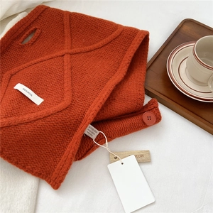 Detailed macro view of rust red 100% wool knit scarf featuring premium diamond texture