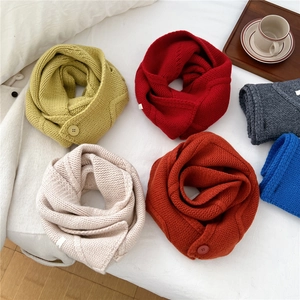Cross-knit wool scarf set in multiple colors with button detail on soft white fabric