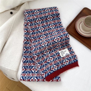 Gros plan sur l'écharpe en tricot géométrique rouge et bleu avec étiquette blanche